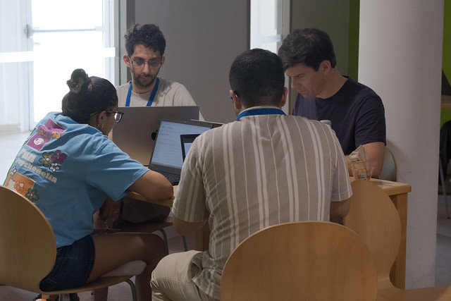 GCC2026 CoFest participants collaborating around laptops.